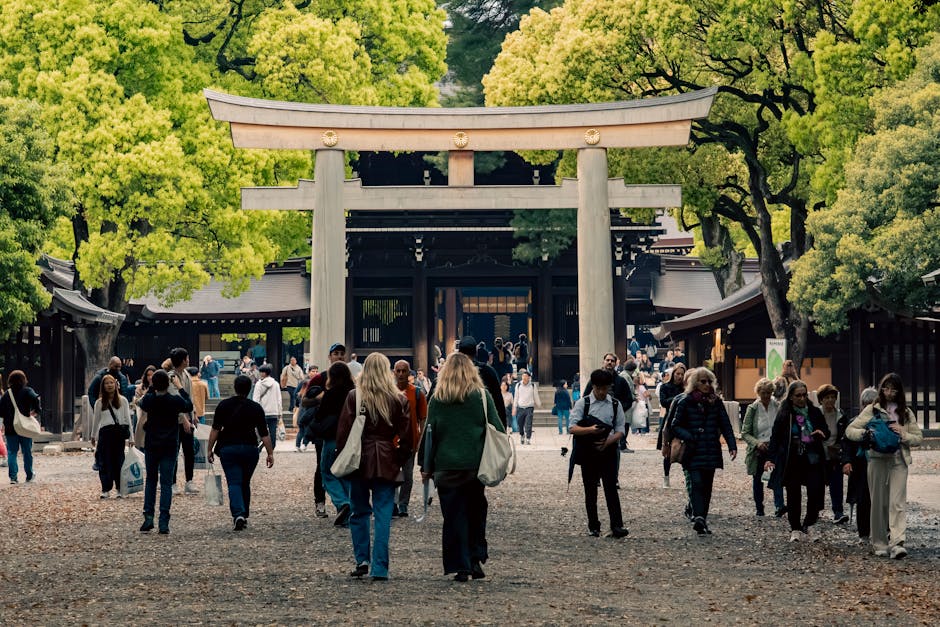 Visitors exploring a vibrant street near a traditional torii gate in Shibuya, Tokyo, Japan.