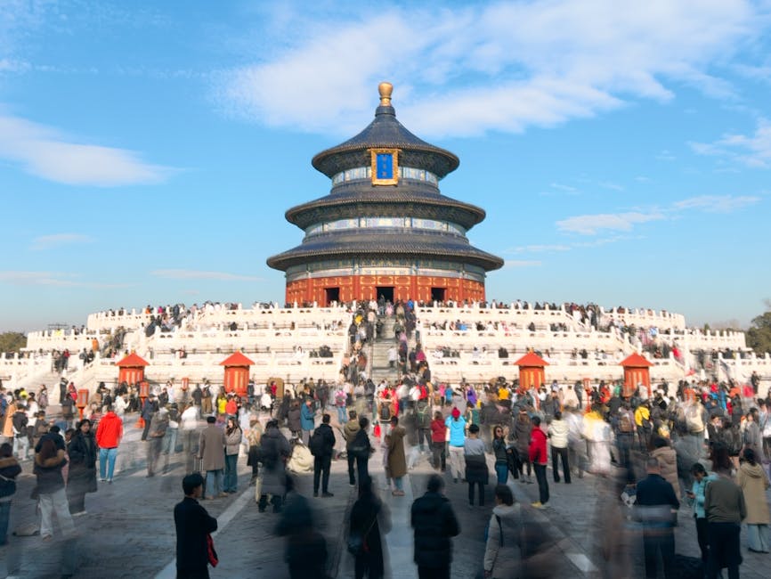 View of the iconic Temple of Heaven in Beijing, bustling with visitors under a clear blue sky.